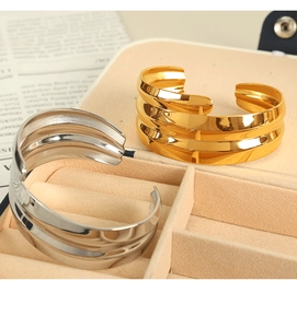 Close-up of gold and silver plated open cuff bracelets in a jewelry gift box