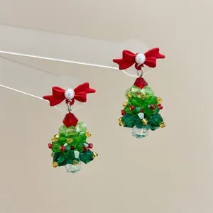 Detail showing crystal beaded Christmas tree earrings with red bows and white pearls