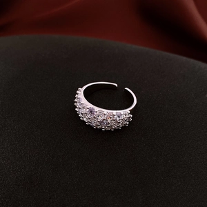 Detail of silver-tone wide open ring featuring multi-row pave-set cubic zirconia stones