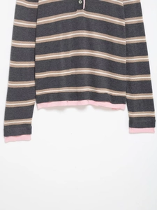 Detail of striped knit sweater showing textured fabric and pink contrast hem finishing