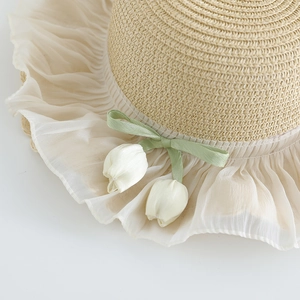 Straw sun hat with green ribbon bow, tulip charms and lace trim in a beige finish