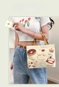 Detail of canvas tote bag showing cute bear and floral print on cream-white fabric