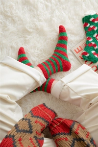 Detail of soft coral fleece Christmas socks featuring festive red and green stripes