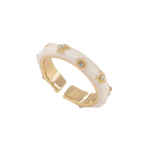 Adjustable gold ring with cream enamel and star-shaped crystal floral accents