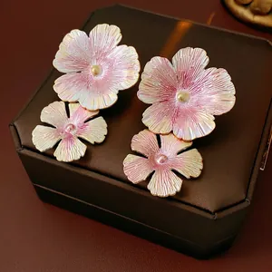 Pink enamel flower earrings with gradient pearl finish on vintage jewelry box background