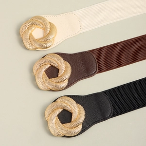 Close-up of elastic belts with gold metal ring buckles in black, brown, and cream