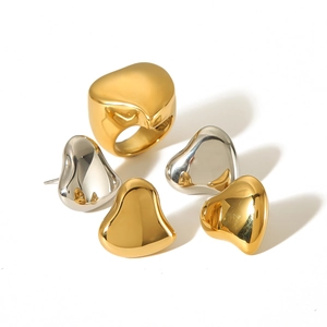 Polished gold and silver stainless steel heart rings and earrings set on white background