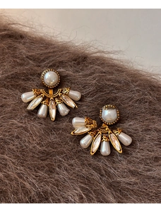 Vue macro de boucles d'oreilles vintage en forme d'éventail, perles et strass