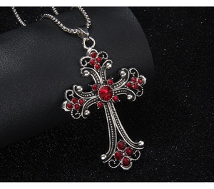Close-up of vintage hip hop cross necklace with sparkling red rhinestones and silver chain