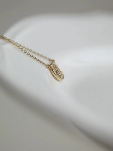 Macro view of a 14k gold plated S925 silver round pendant with pavé setting craftsmanship