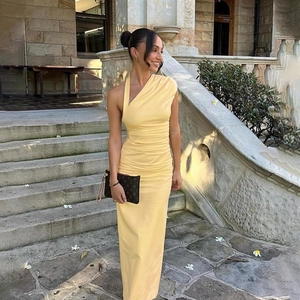 Detail of light yellow one-shoulder maxi dress with ruched side and satin finish