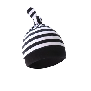 Close-up of soft black and white striped newborn hat with a top knot design and smooth fabric