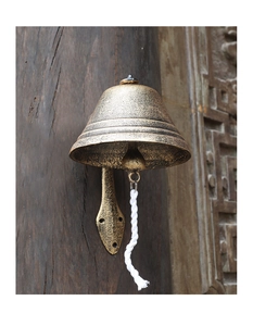 Macro detail of rustic cast iron garden doorbell with vintage bronze finish and white pull rope
