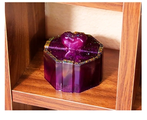 Macro shot of a purple heart-shaped resin jewelry box with shimmering glitter details