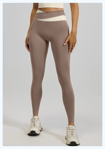 Detalle de mallas de yoga de cintura alta con diseño cruzado y colores en contraste