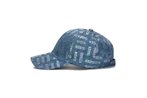 Macro detail of the holographic Queen text print on blue denim baseball cap surface