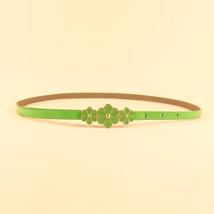 Detail of green skinny belt with three floral ornaments and adjustable golden buckle holes