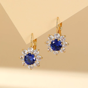 Sparkling sunflower drop earrings with blue center stone and white crystals in gold