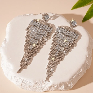 Détail de boucles d'oreilles pampilles argentées avec zircons sur socle en pierre