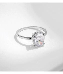 Macro detail of oval cut zircon ring featuring a polished silver four-prong setting