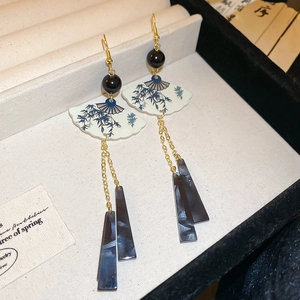 Gros plan de boucles d'oreilles en éventail avec motif bambou et pendentif en résine