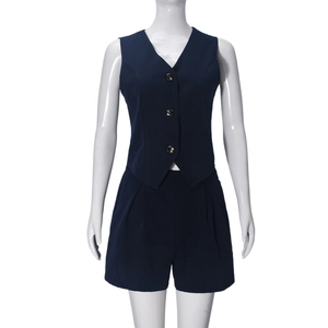 Dettaglio del gilet senza maniche blu scuro e pantaloncini a vita alta con bottoni
