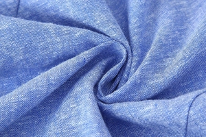 Macro shot of blue linen fabric texture showing natural weave and fiber details