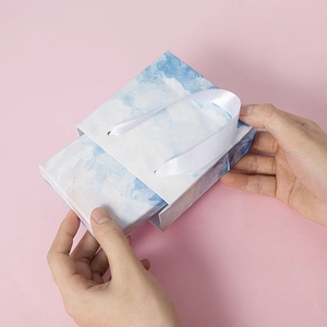 Watercolor starry sky small jewelry gift bag with white ribbon handles on pink background
