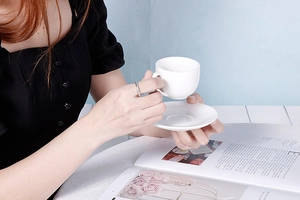 Detail of silver textured ring worn by woman holding a coffee cup for a stylish lifestyle look