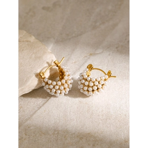 Détail des boucles d'oreilles panier plaquées or 18 carats avec perles sur pierre