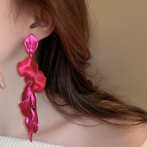 Close-up of rose red petal tassel earrings worn by a model for a stylish look