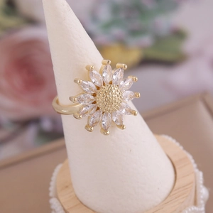 Macro shot of 18K gold plated sunflower ring with colorful cubic zirconia on a stand