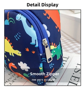 Close-up of smooth metal zipper and colorful dinosaur prints on blue kids chest bag