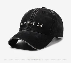 Detail view of washed black cotton baseball cap with white TAO FEI LE letter embroidery