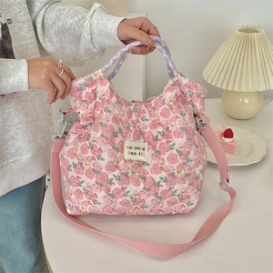 Close-up of pink floral quilted tote bag with sozakka beaute label and purple handles