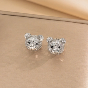 Macro detail of silver bear earrings with sparkling clear cubic zirconia and black zircon eyes