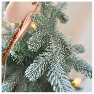 Close-up of grey-green artificial pine needles with shimmering silver glitter and texture