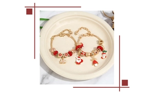Detail of Christmas beaded charm bracelets with Santa and reindeer on a ceramic tray