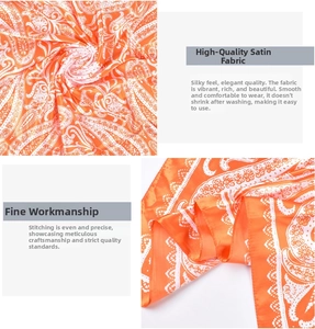 Detail of orange paisley satin scarf showing smooth texture and fine hemmed edges