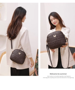 Detail view of dark brown quilted shell bag with elegant gold metal butterfly decoration