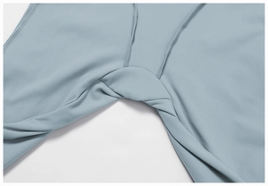 Dettaglio della cucitura rinforzata del cavallo su body sportivo grigio-blu da yoga