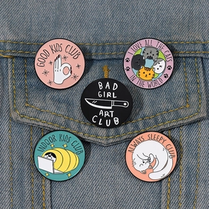 Detailed set of 5 cartoon cat club enamel pins displayed on denim jacket pocket