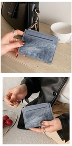 Close-up of grey-blue denim texture mini card holder with zipper and gold chain hook