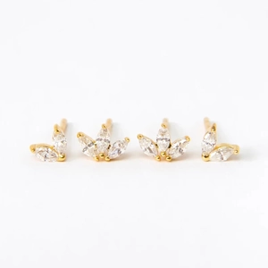 Macro detail of 925 sterling silver gold earrings with marquise-cut zircons in petal design