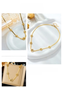 Detail of gold tree of life necklace featuring zircon accents and sleek snake chain