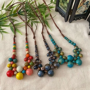 Colliers ethniques en perles de céramique bohème colorées sur fond en lin naturel