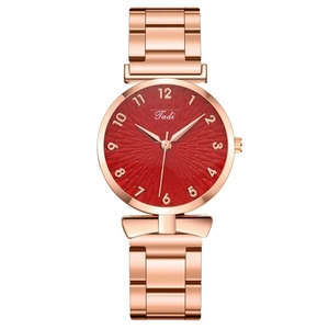 Detail of rose gold ladies watch with sunburst red dial and Arabic numerals