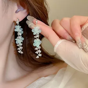 Elegant floral tassel earrings featuring pale green matte flowers and silver chains