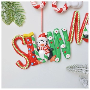 Detail of polymer clay Christmas penguin and candy cane ornament with hanging rope