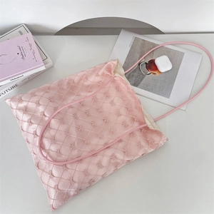 Detail of light pink tote bag featuring delicate butterfly embroidery and mesh texture